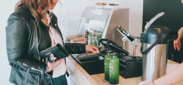 Young women paying for drinks with credit or debit card