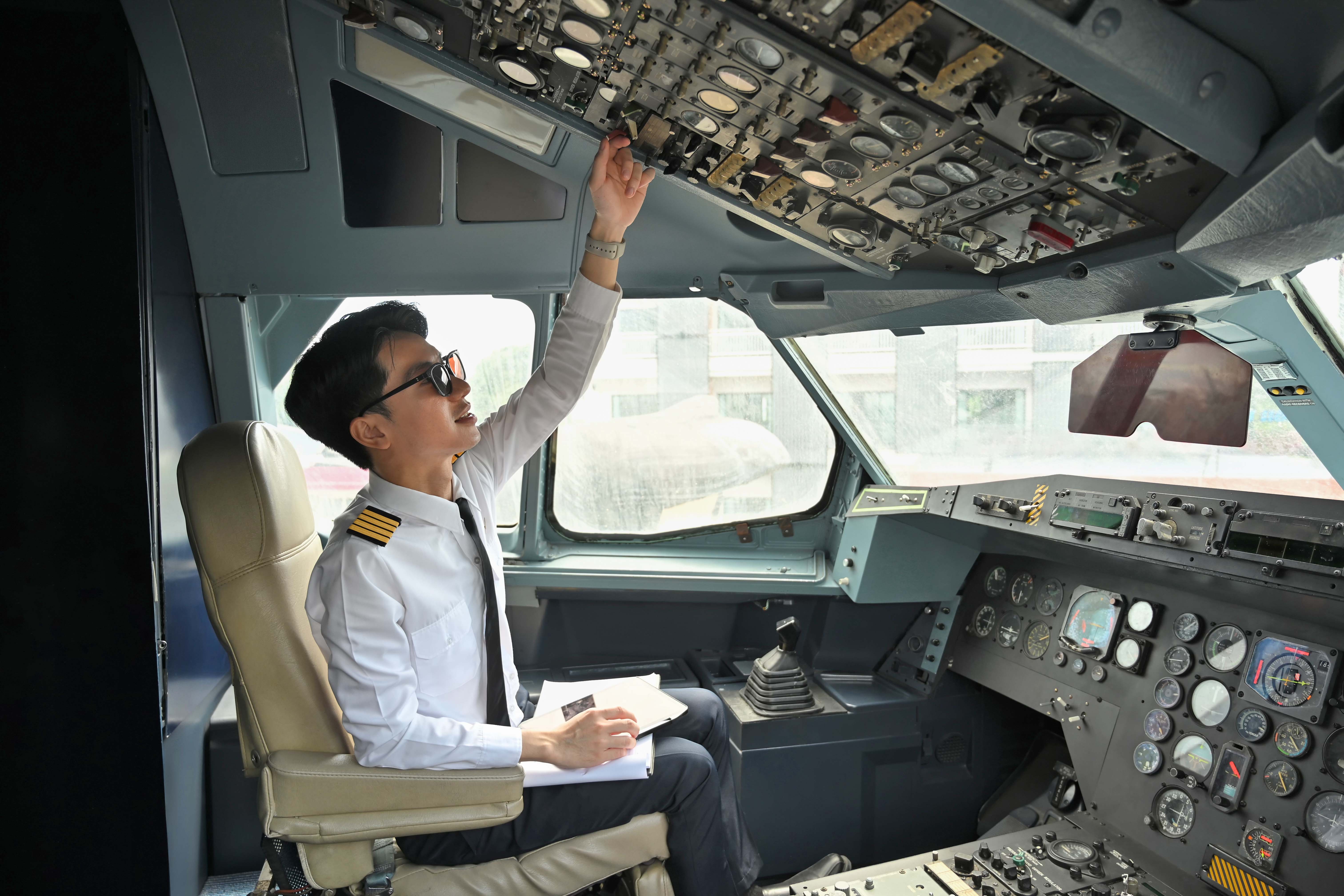 Pilot completing preflight checks in plane cockpit.