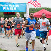 People running through the finish line of a 5k race