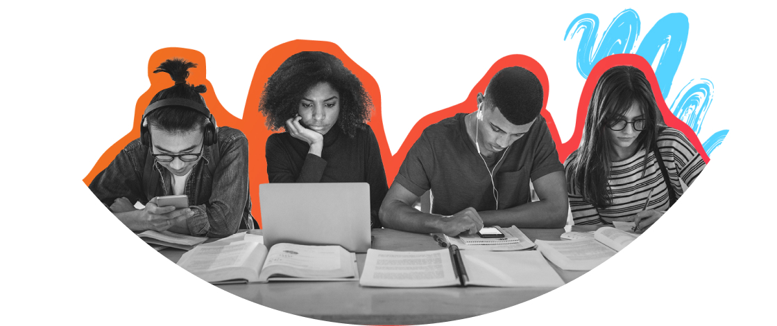 Four students sitting at a table with laptops and books.