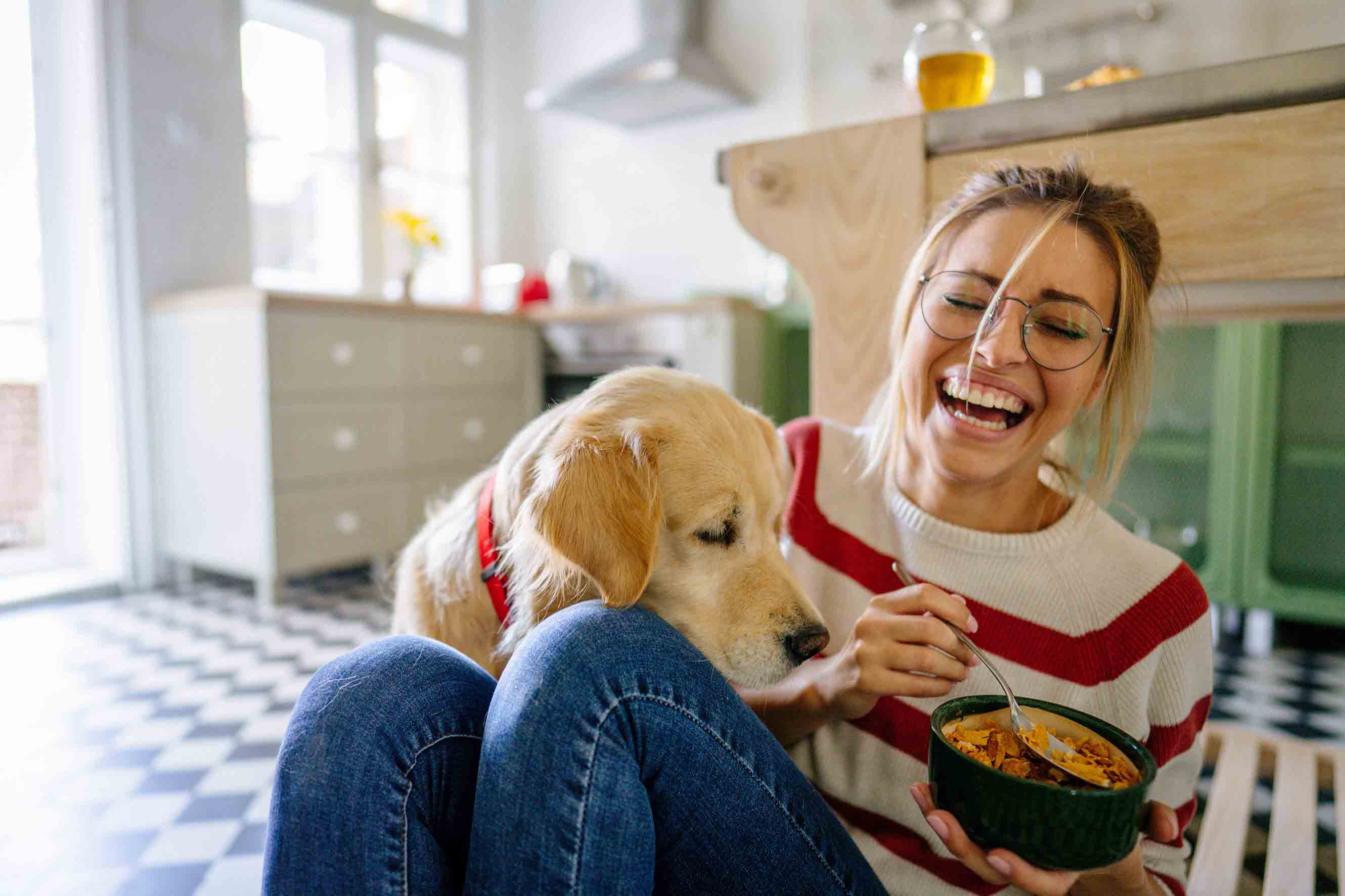 Sitting on the kitchen floor with their dog.