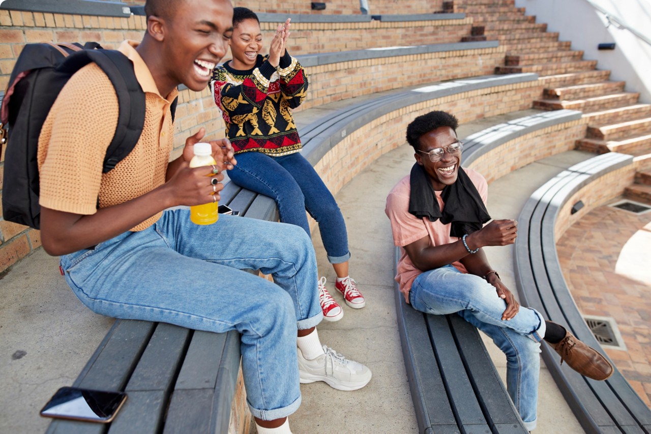 Student sitting in an outdoor amphitheater laughing together. 
