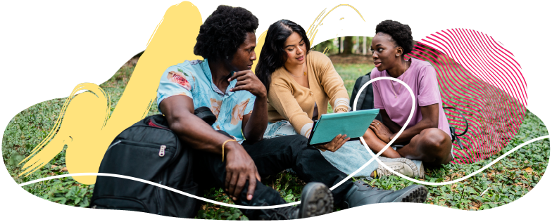 Students sitting on lawn working on project together.