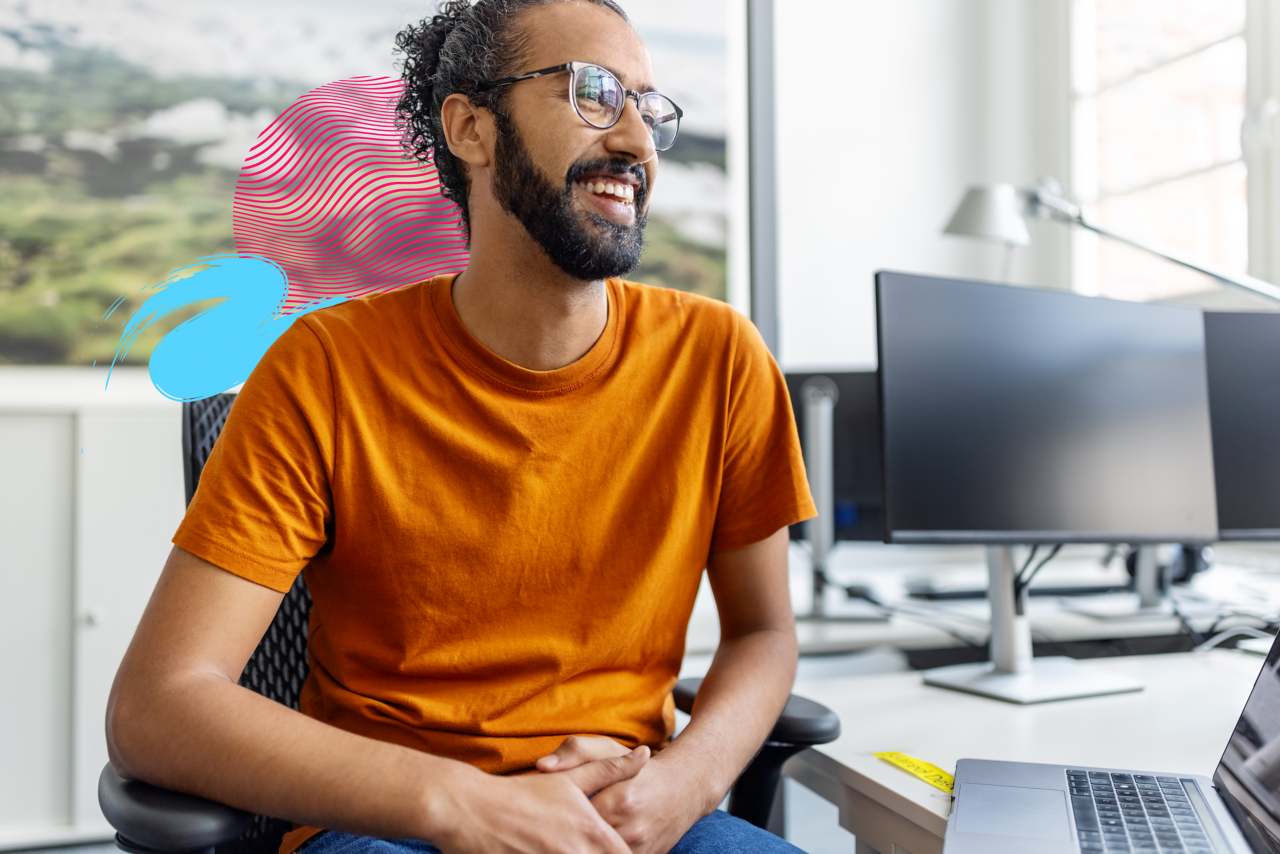 Graduate student casual relaxed smiling at office desk. 