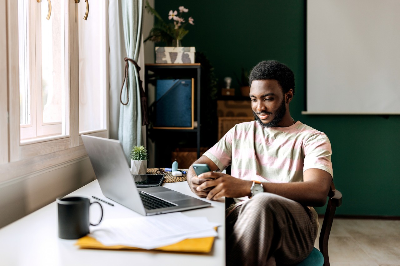 Graduate student at home desk, relaxed. 