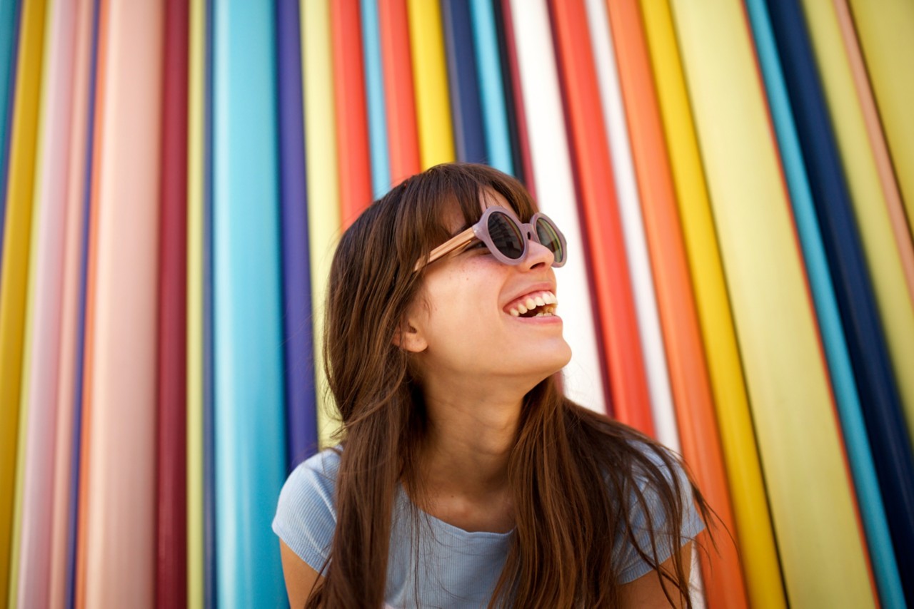 Happy person in front of colorful backdrop.