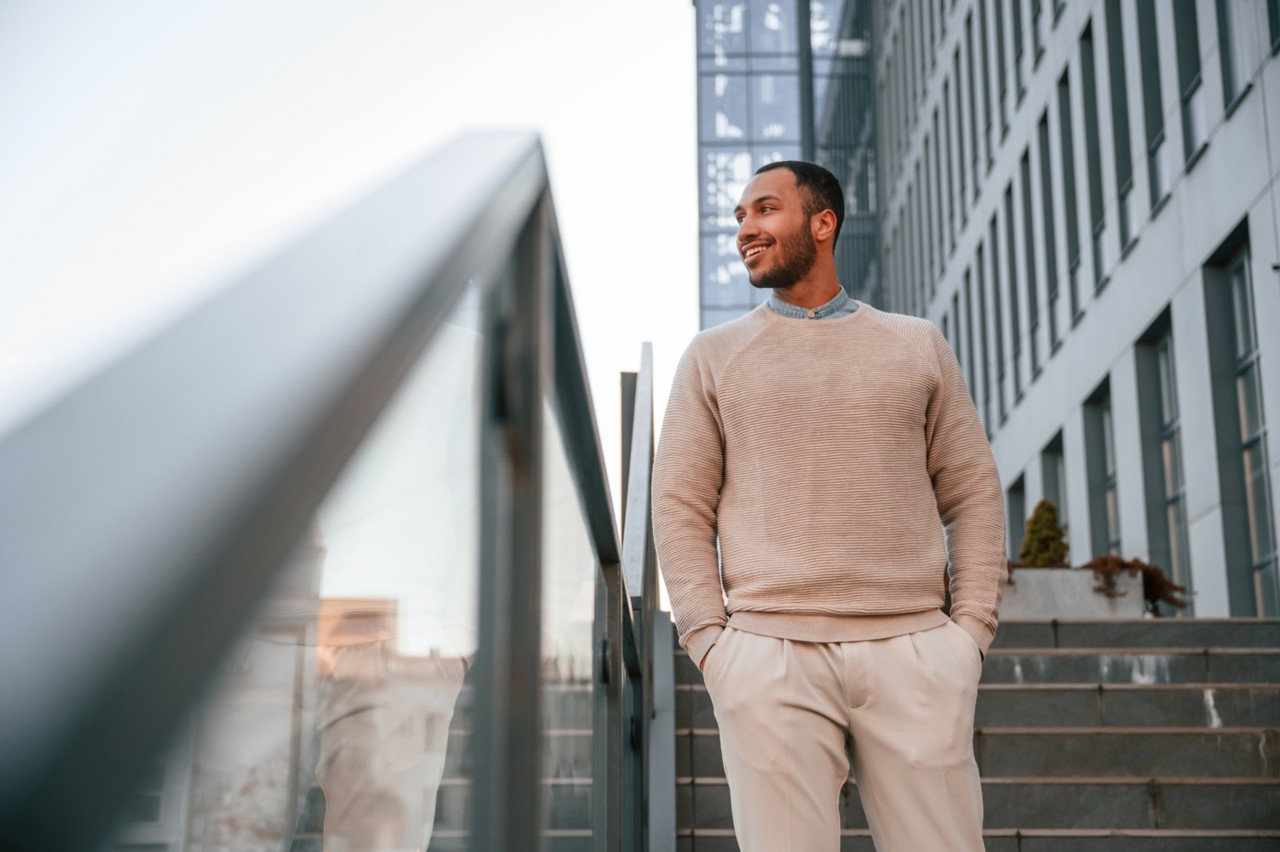 Relaxed young adult walking down steps and looking at the city.