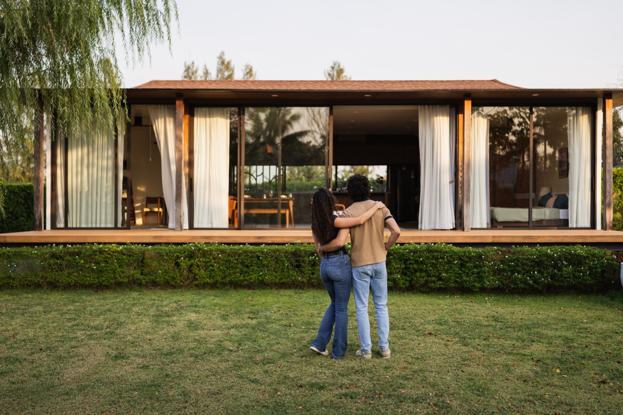 New homeowners standing in front of new house.