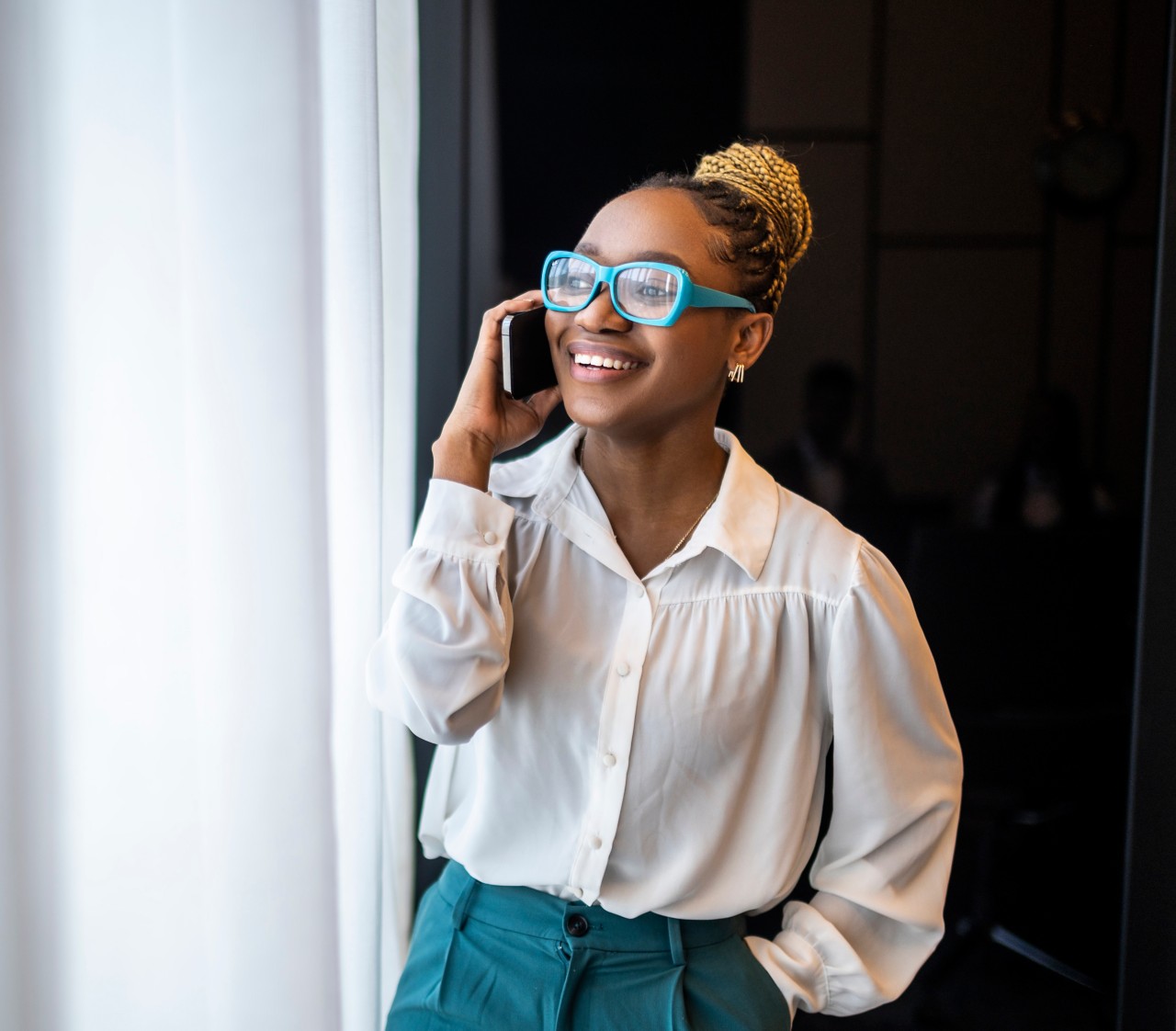 Person talking on phone by window.