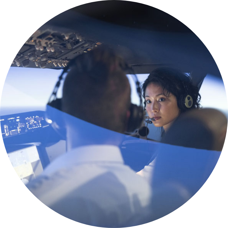 Young woman taking a flight course with an instructor in a flight simulator